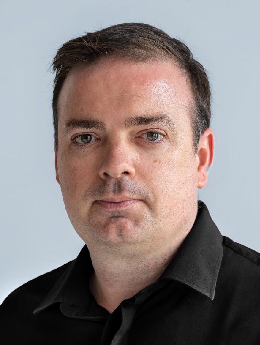 Portrait of David Vivancos in a black shirt against a pale background.